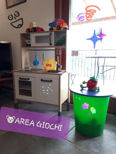a toy kitchen with a table and a green trash can at Sole & Lago-Lake in Maccagno con Pino e Veddasca