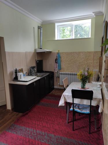 a kitchen with a table and a sink and a table and chairs at Inexpensive house in Vanadzor