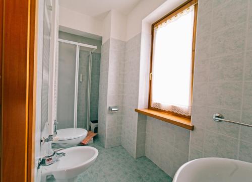 baño con 2 lavabos y ventana en Kapriol, en Castello Tesino