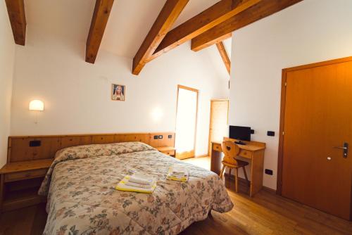 a bedroom with a bed and a desk at Kapriol in Castello Tesino