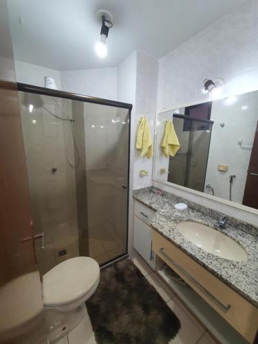 a bathroom with a shower and a toilet and a sink at Apartamento quadra praia com vista mar in Guarapari