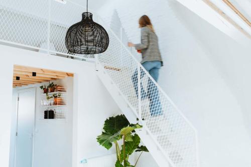 a woman walking down the stairs in a house at Musa Antwerp in Antwerp