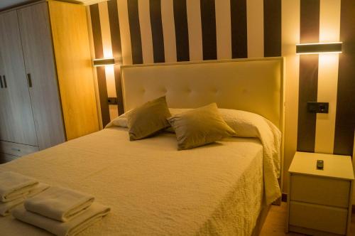 a bedroom with a white bed with two pillows at Pensión Catamaran in Castro-Urdiales