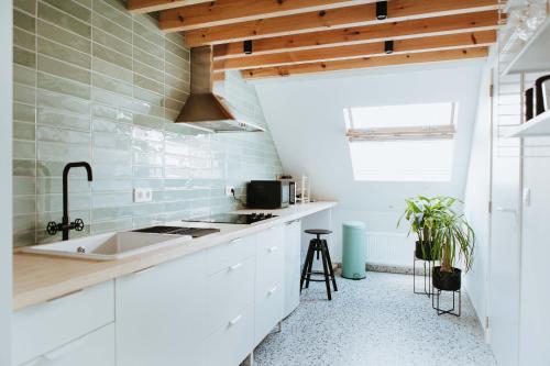 uma cozinha com armários brancos e um lavatório em Musa Antwerp em Antuérpia