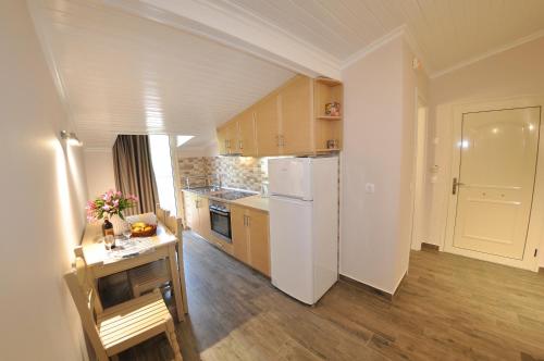 a kitchen with a white refrigerator and a table at Dina's Paradise in Agios Gordios