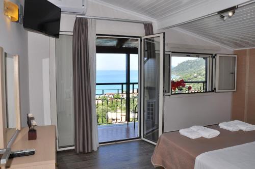 a hotel room with a view of the ocean at Dina's Paradise in Agios Gordios