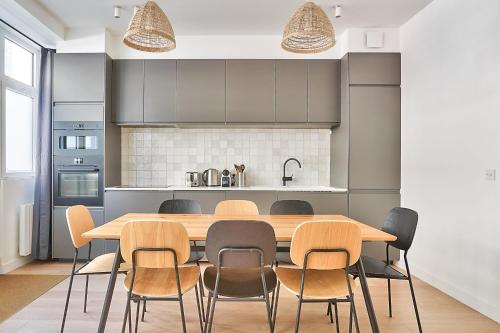 een eetkamer met een houten tafel en stoelen bij GuestReady - Modern flat near Latin Quarter! in Parijs