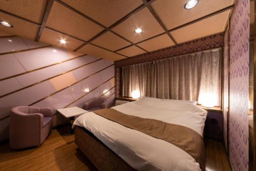 a bedroom with a large bed and a window at Hotel Chapel Story Sakai in Sakai