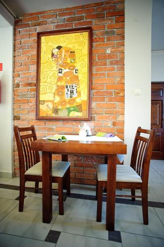 a wooden table and two chairs in front of a brick wall at Zajazd na Towarowej in Dęblin