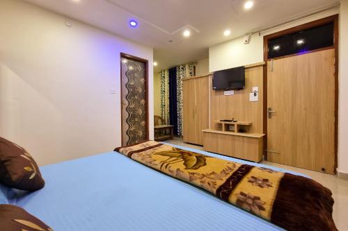 a bedroom with a bed and a flat screen tv at Mohan Home Stay in Dalhousie