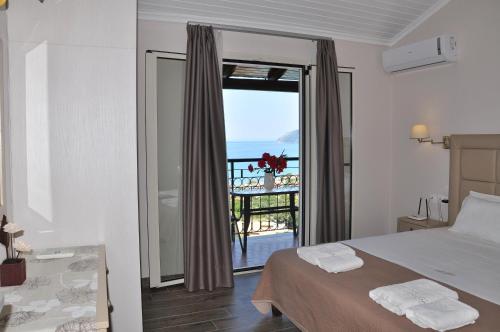 a bedroom with a bed and a view of the ocean at Dina's Paradise in Agios Gordios