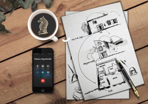 a remote control next to a drawing of a house at Maison de charme, d'artiste, décoration brocante in Aigrefeuille-dʼAunis