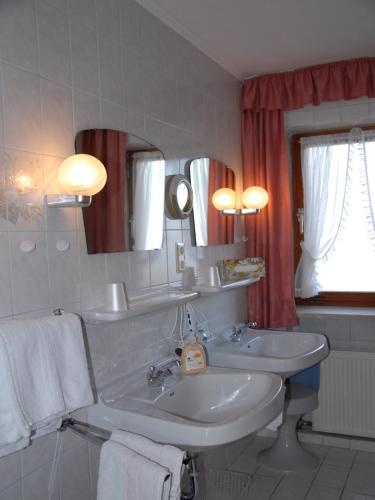 a bathroom with two sinks and a mirror at Gästehaus Gamsei - Bosch Hermann in Grassau