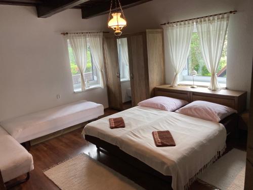 a bedroom with two beds and two windows at Chalupa na samote in Pliešovce