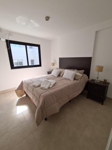 een slaapkamer met een groot bed en een raam bij DOS ANGELES in Salta