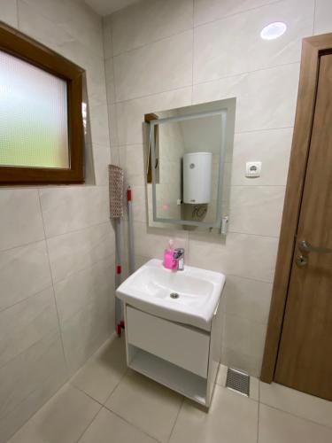 a bathroom with a white sink and a mirror at Villa Dardania in Peje