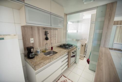 Il comprend une cuisine équipée d'un évier et d'une cuisinière. dans l'établissement Apartamento Encantador Verano na Praia, à Natal