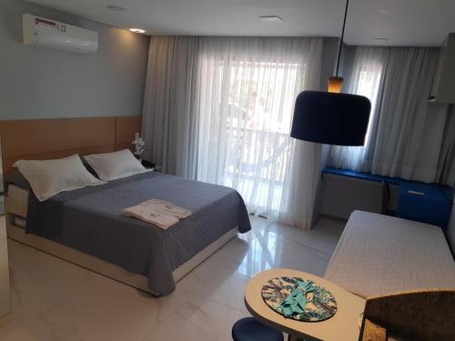 um quarto com uma cama e uma sala de estar em Marulhos Resort Studio Master em Porto de Galinhas