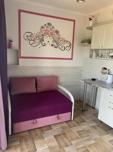 a room with a purple couch in a kitchen at Flower Breeze in Chebanka