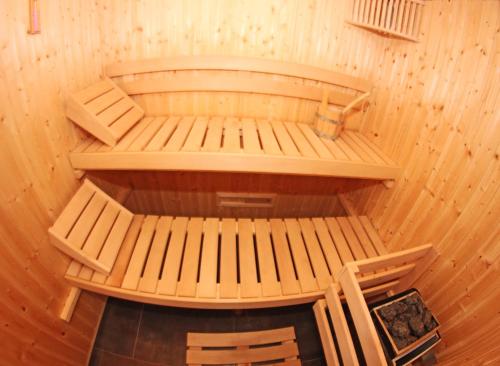 a room with two wooden benches in a sauna at Au Pré Carré in Plumergat