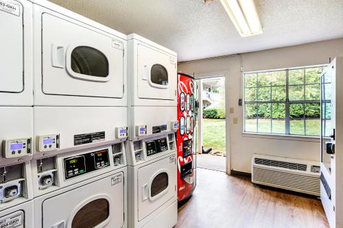a garage with four washer and dryer machines at HomeTowne Studios by Red Roof Atlanta – Lawrenceville in Lawrenceville
