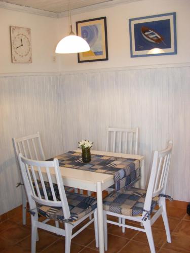 a dining room table with two chairs and a table and a lamp at Apartment Petra in Tribunj