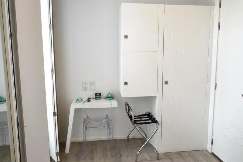 a desk in a room with a chair and a cabinet at Hotel Alda San Bieito in Santiago de Compostela
