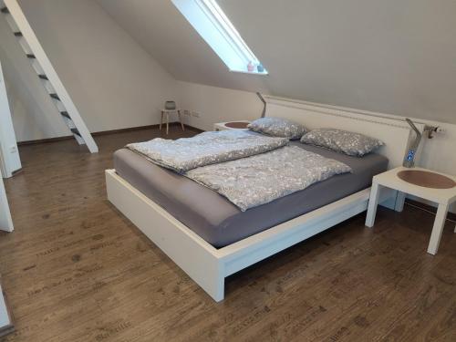 un letto in una camera bianca con gonna da letto tspectssenalsenalsenalsenalenalenale di Ferienwohnung Neugebauer a Bockhorn