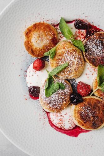 a plate of food with donuts and berries on it at Green Town in Vievis