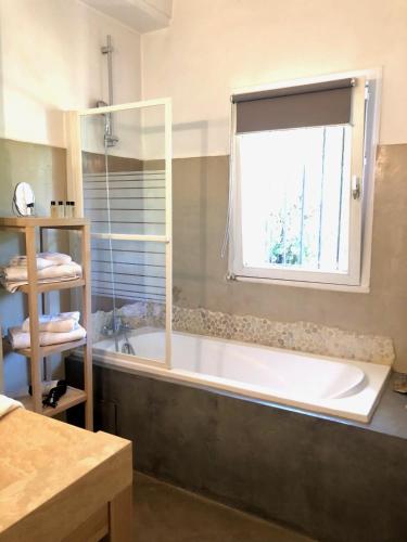 une salle de bain avec une baignoire et une fenêtre dans l'établissement B&B Villa Roumanille, à Aix-en-Provence