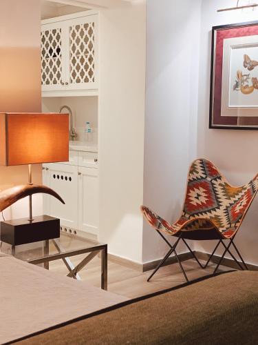a living room with a chair and a table at Garden Suites in Corfu