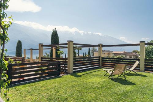 a yard with a chair and a fence with mountains at Hotel Caravel in Limone sul Garda