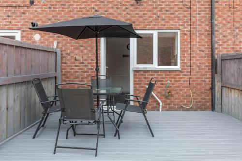 a table and chairs with an umbrella on a patio at Number Four in Westoe