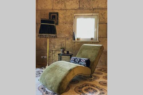 a living room with a couch and a chair at Forest house for family in Lebeniškiai