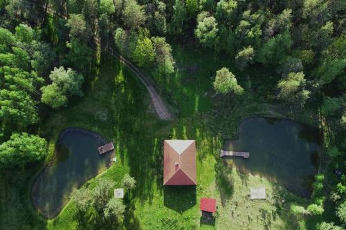 an aerial view of two ponds and a house at Forest house for family in Lebeniškiai