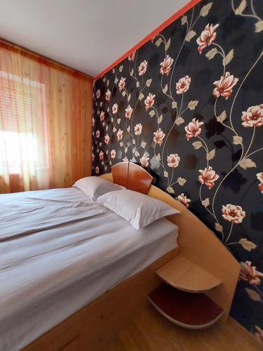 Schlafzimmer mit einem Bett mit Blumentapete in der Unterkunft Apartament Akim in Târgu Ocna