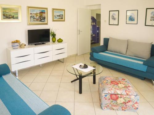 a living room with two blue couches and a tv at Holiday Home Katarina - SRD330 by Interhome in Rovanjska