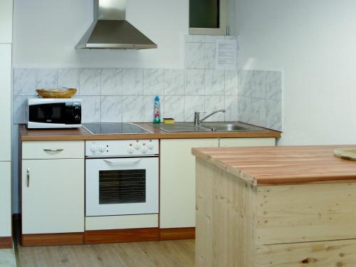 een keuken met een wit fornuis en een wastafel bij Apartment Haupthaus Schönblick - SVH118 by Interhome in San Valentino alla Muta