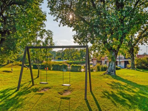 a swing set in a park with a tree at Apartment Oak-2 by Interhome in Sorano