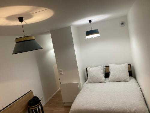 Cette chambre comprend un lit avec deux lumières et deux oreillers. dans l'établissement Studio Zen - Shopping center and train station 500m - Disneyland Paris 5min, à Montévrain
