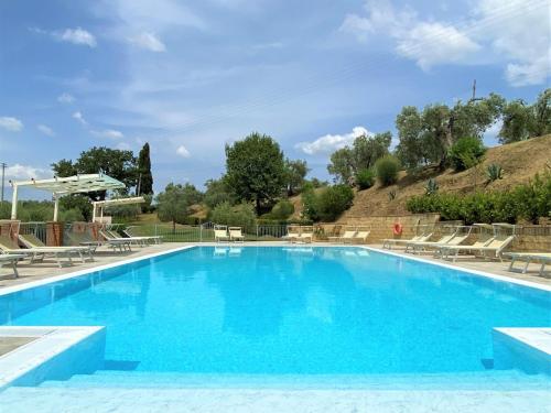 a large swimming pool with blue water at Apartment Stregaia-1 by Interhome in Montaperti