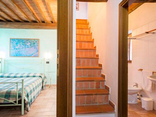 a bedroom with a staircase and a bed and a bathroom at Apartment Stregaia-1 by Interhome in Montaperti