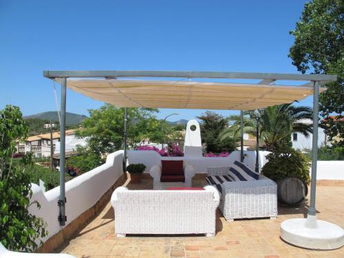 a pergola with two chairs and a couch under it at Holiday Home Dolce Farniente - PCN130 by Interhome in Cala Mendia