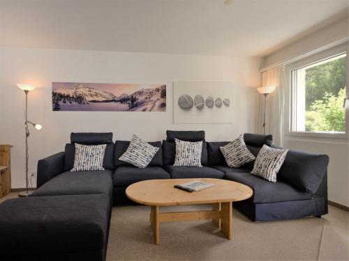 ein Wohnzimmer mit einem Sofa und einem Tisch in der Unterkunft Apartment Chesa Flora 53 by Interhome in St. Moritz