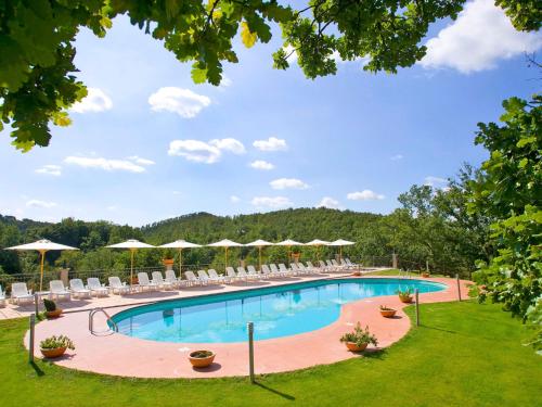 a large swimming pool with chairs and umbrellas at Apartment Oak-4 by Interhome in Sorano