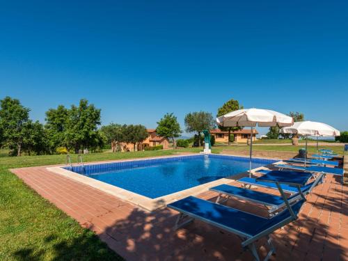 a swimming pool with lounge chairs and an umbrella at Holiday Home Arancio by Interhome in Preselle