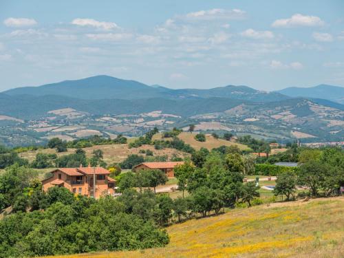 a house on a hill with mountains in the background at Holiday Home Arancio by Interhome in Preselle