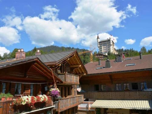 a large wooden building with flowers in front of it at Apartment Le Vieux Chalet by Interhome in Gstaad