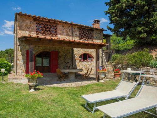 una casa de piedra con 2 sillas y una mesa en un patio en Holiday Home Badia a Passignano by Interhome, en Badia A Passignano