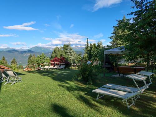 a yard with two lounge chairs and a table at Apartment Pensione Villa Belfiore-1 by Interhome in Ronzone